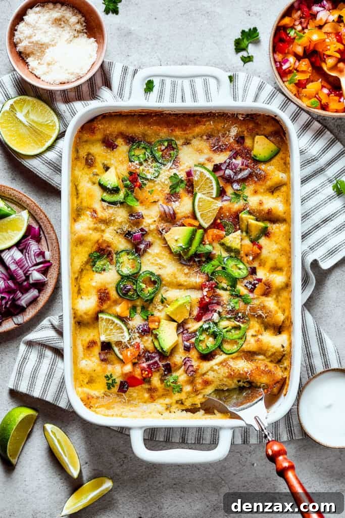 Baked shrimp enchiladas with fresh toppings of avocado, cilantro, and red onion, gleaming with melted cheese.