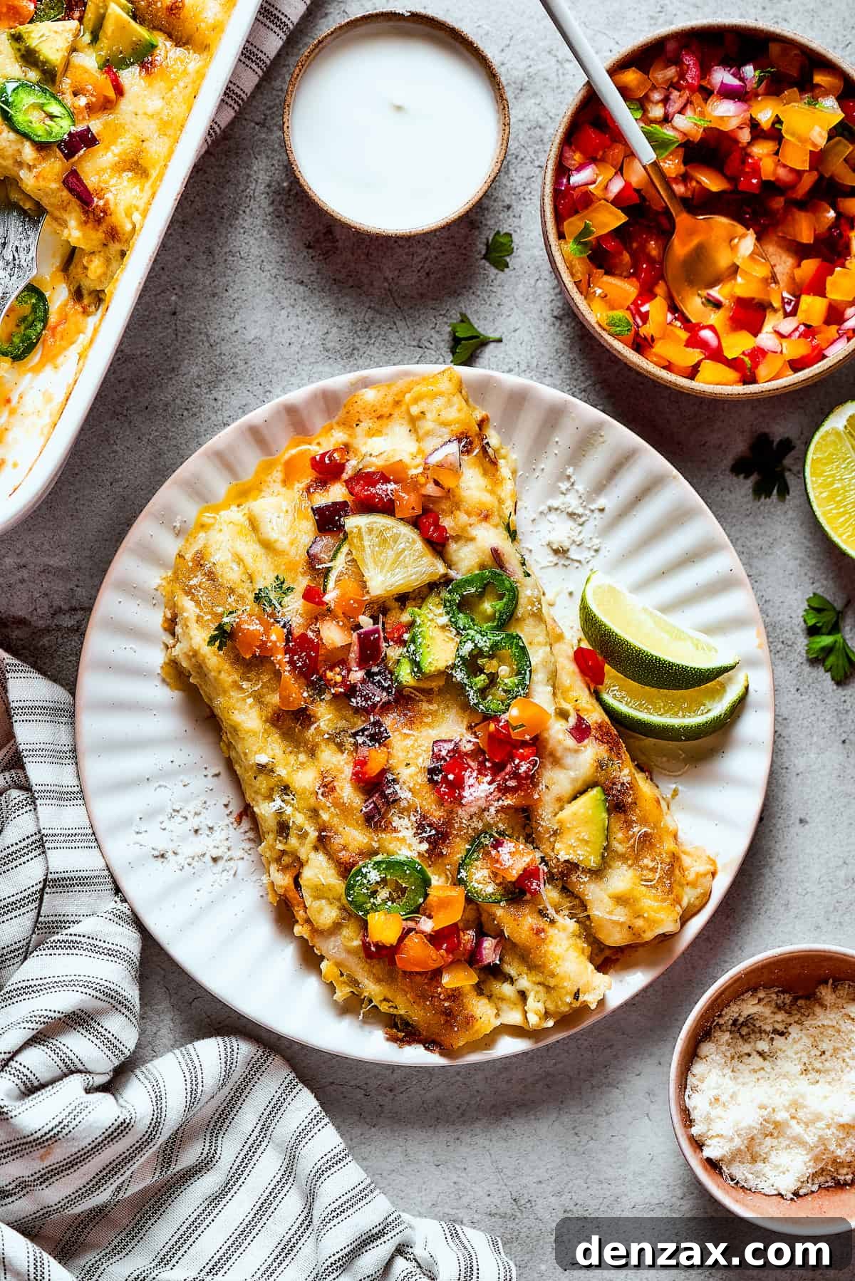 Two perfectly portioned shrimp enchiladas on a plate, garnished with fresh cilantro and a lime wedge.