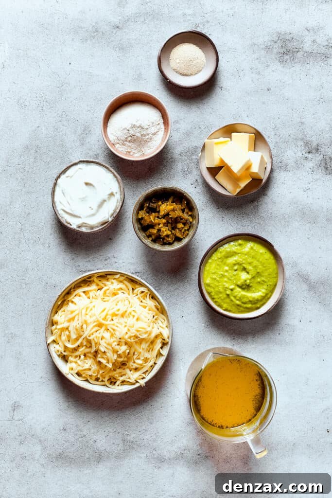 Ingredients for enchilada cheese sauce, measured and arranged on a table, including butter, flour, broth, sour cream, and cheese.
