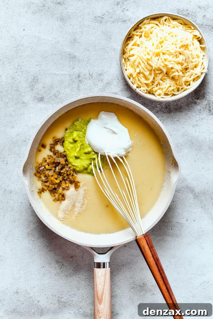 Making a creamy green enchilada sauce in a skillet, showing the blending of ingredients.