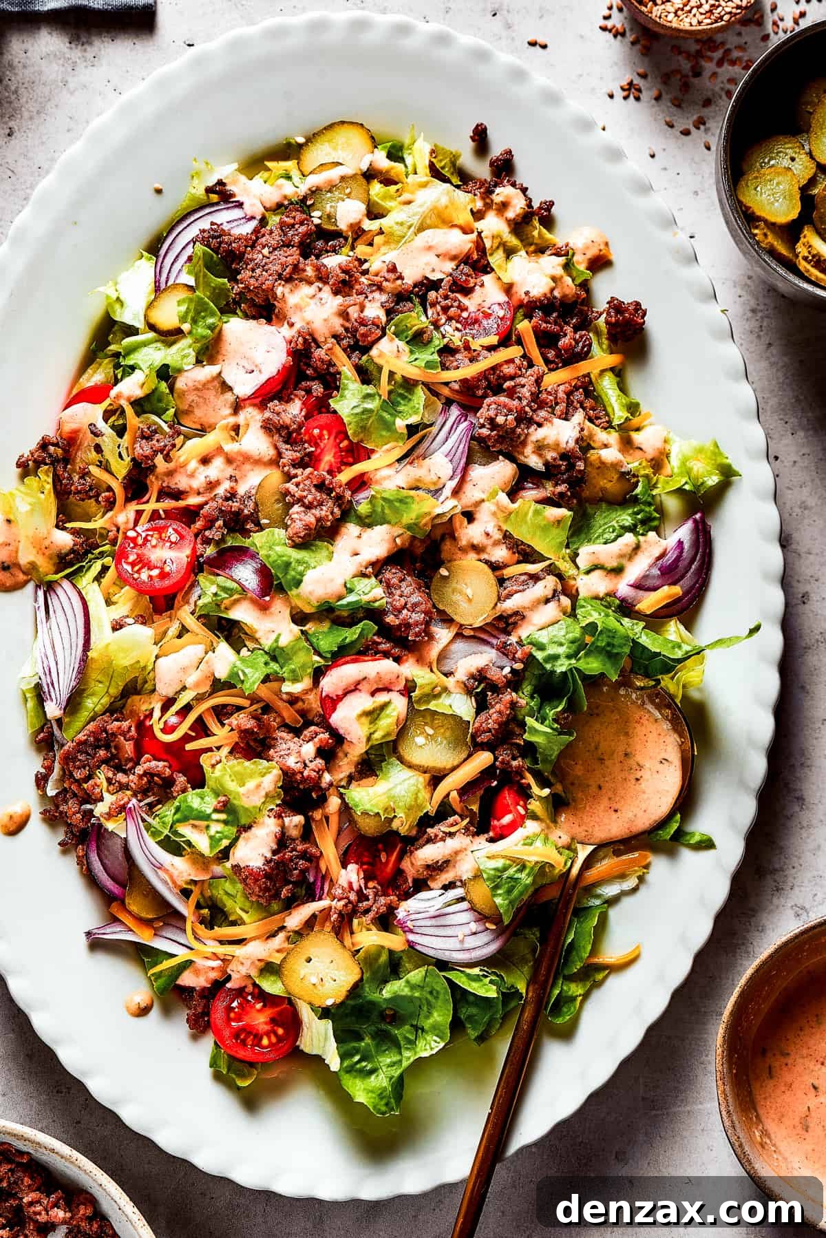 Overhead shot of a vibrant Big Mac salad on a pristine white oval platter, ready to be enjoyed.