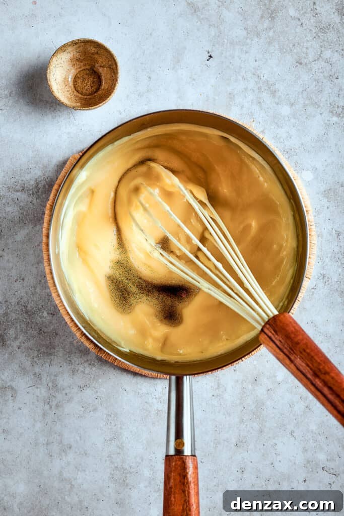 The thickened banana pudding simmering gently in a saucepan, showcasing its creamy, rich consistency after cooking.
