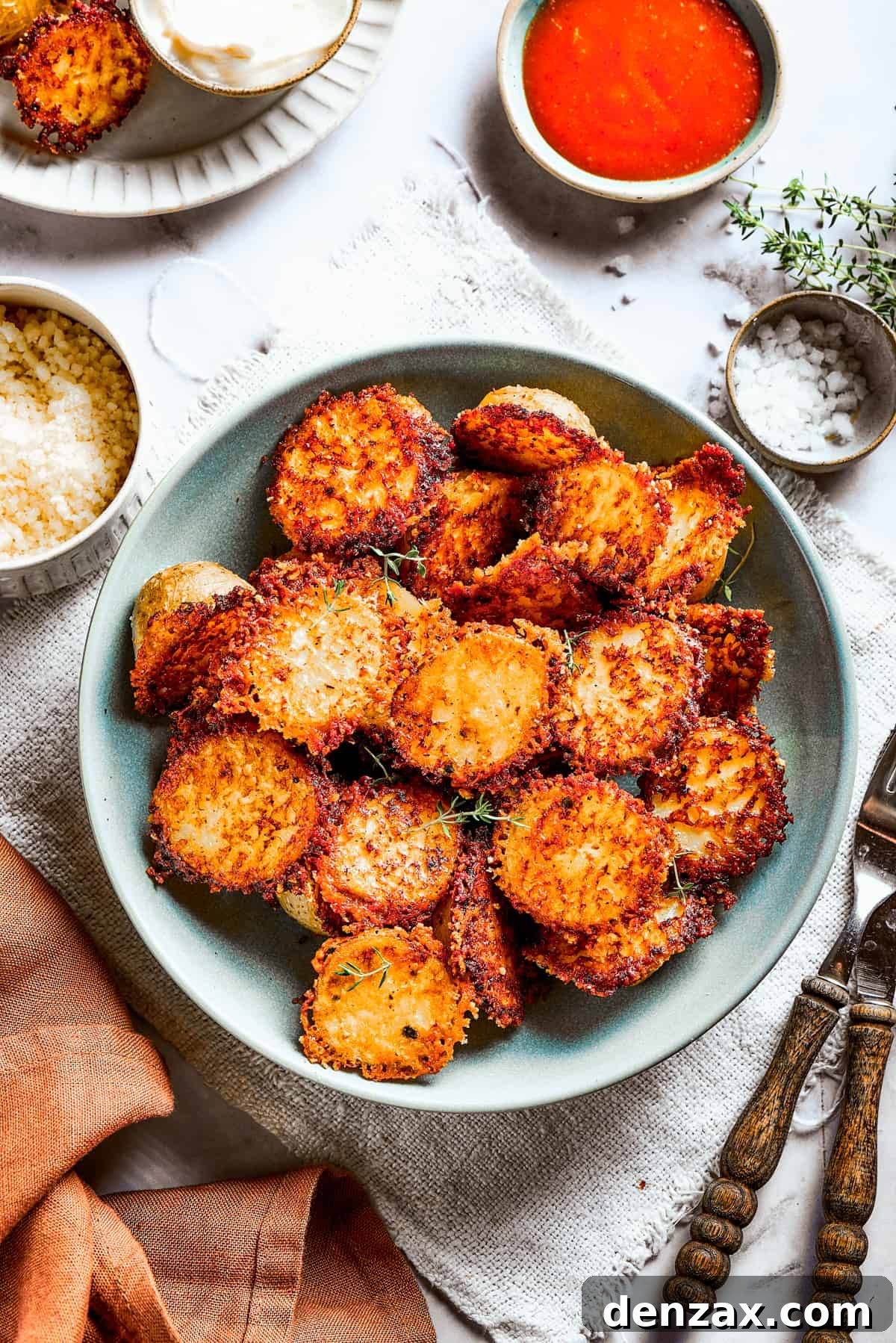 A bowl of baked potato halves beautifully crusted with Parmesan cheese, ready to be enjoyed.