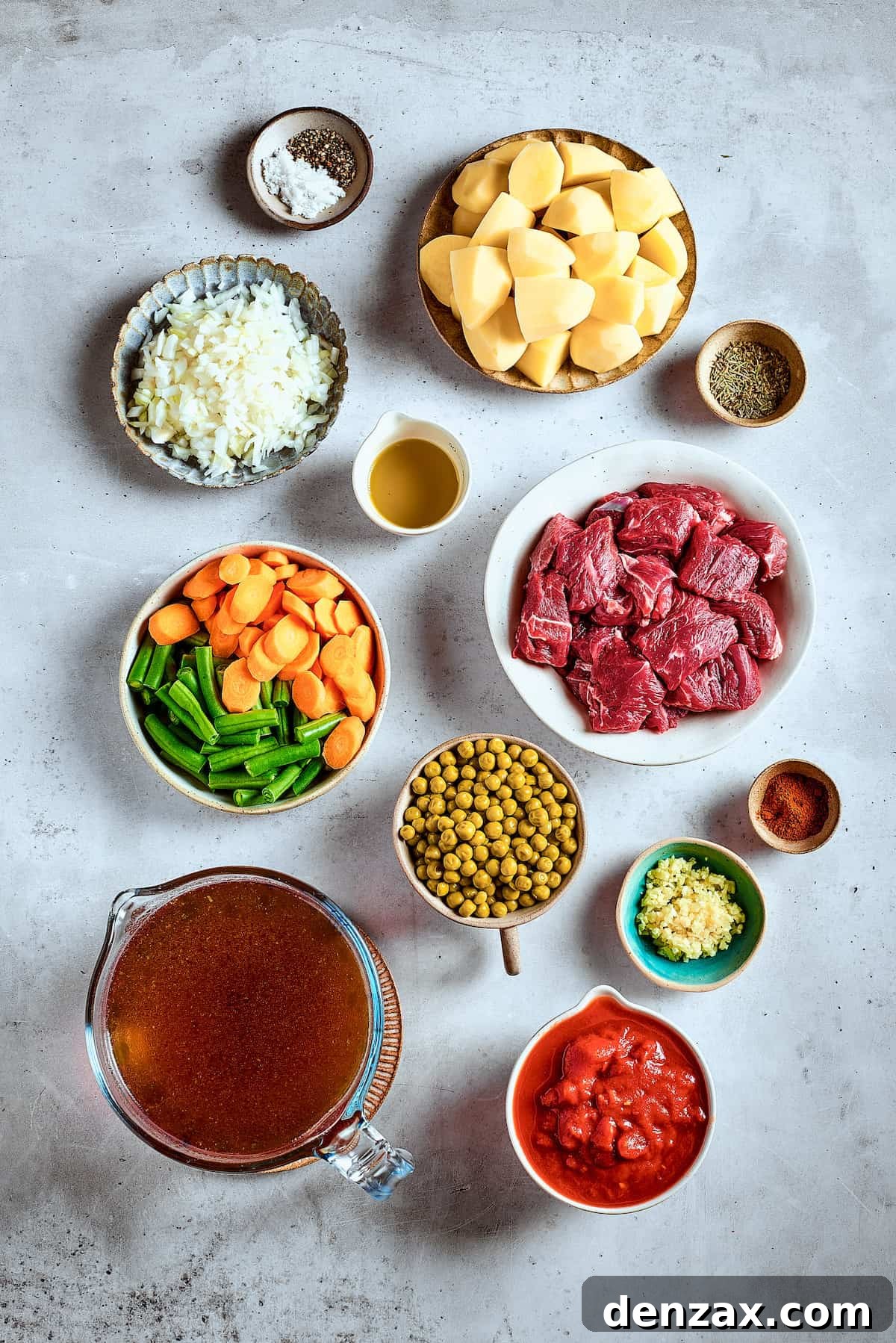 Ingredients for Mulligan stew neatly arranged on a rustic wooden table.