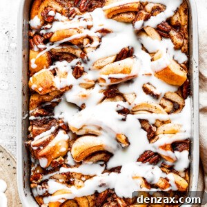 Overhead view of a cinnamon roll casserole in a baking dish, covered in icing