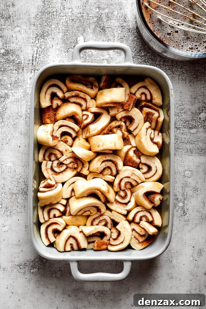 Overhead view of pieces of unbaked cinnamon rolls in a baking dish