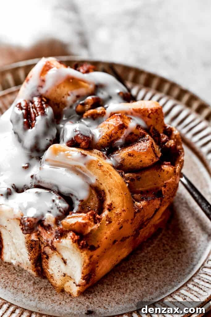 Close up of a square of cinnamon roll casserole on a plate with a fork
