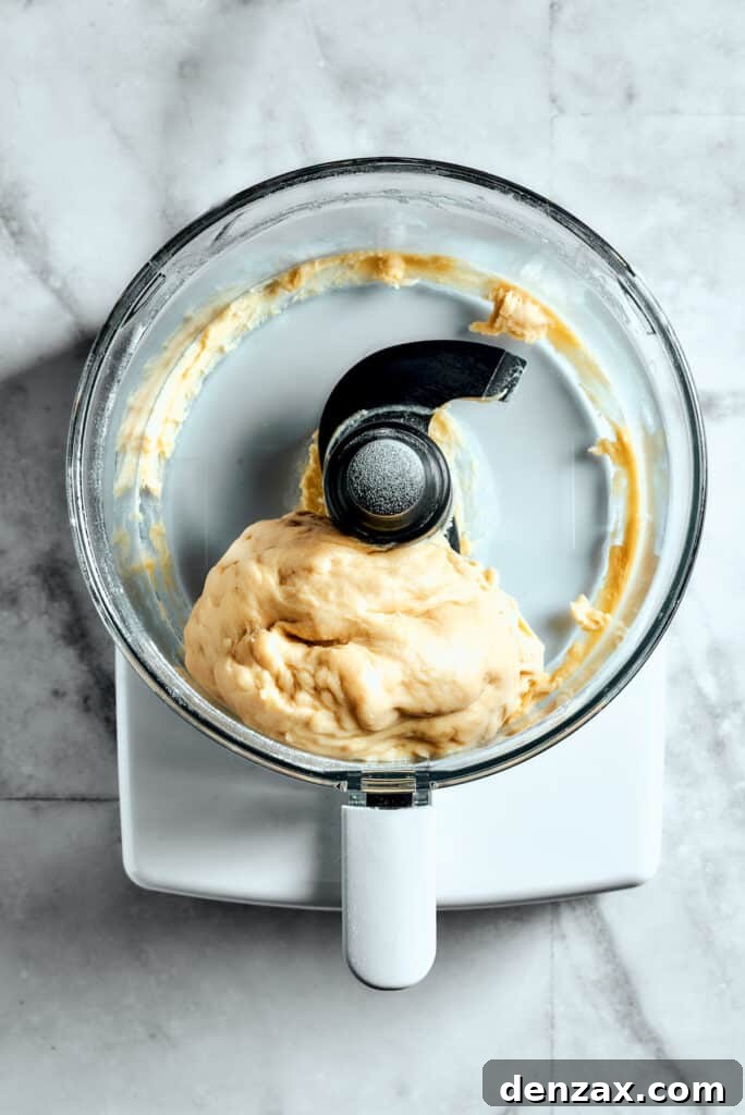 Overhead view of the star bread dough forming a cohesive ball within a food processor after initial mixing.