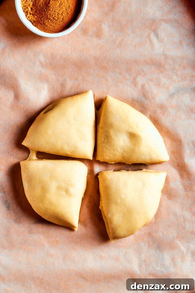 Overhead view of the risen dough neatly cut into 4 equal segments, ready for rolling.