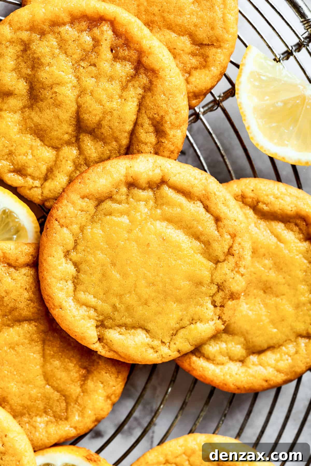 Close-up shot of several lemon cookies arranged on a round wire rack, highlighting their soft, tender, and chewy texture.
