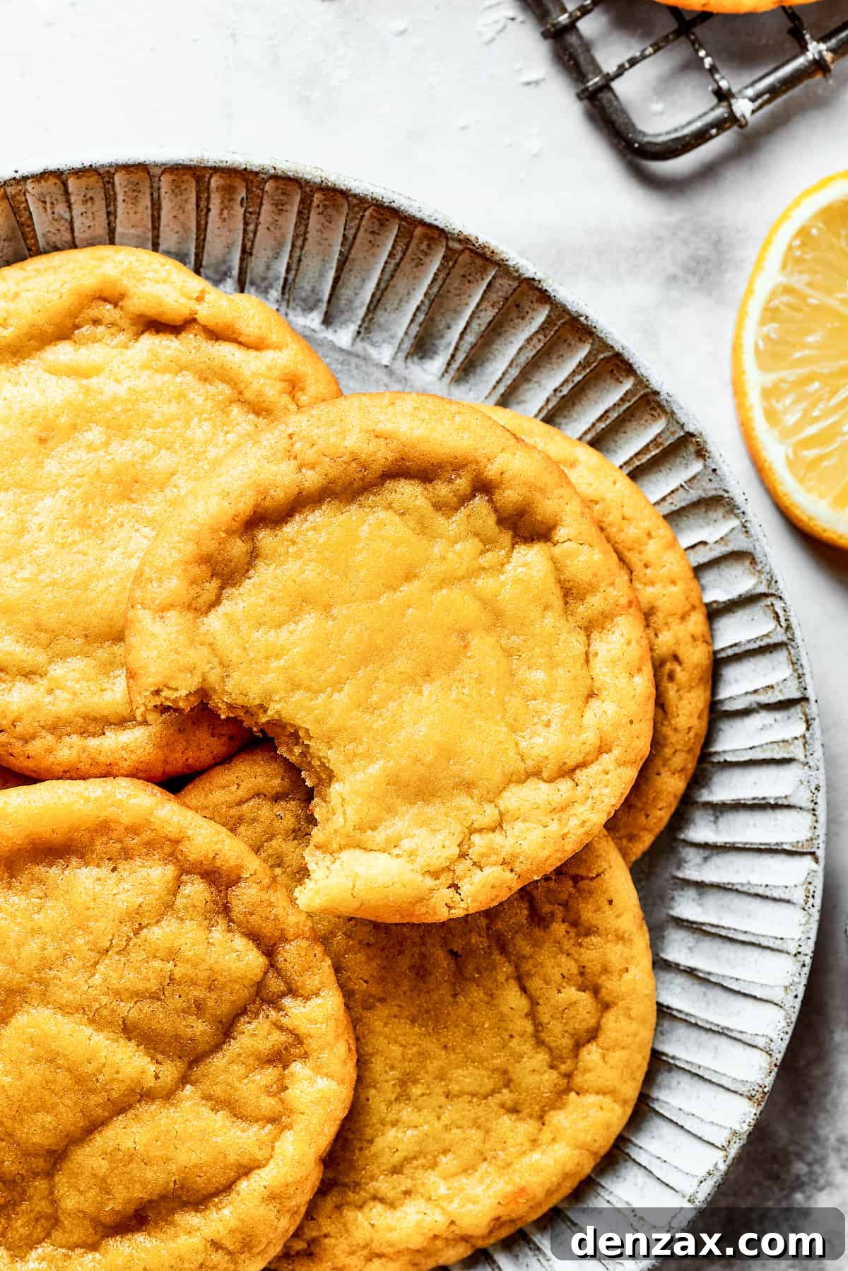 A charming plate of golden-yellow lemon cookies, perfectly baked and ready to be enjoyed, showcasing their inviting texture.