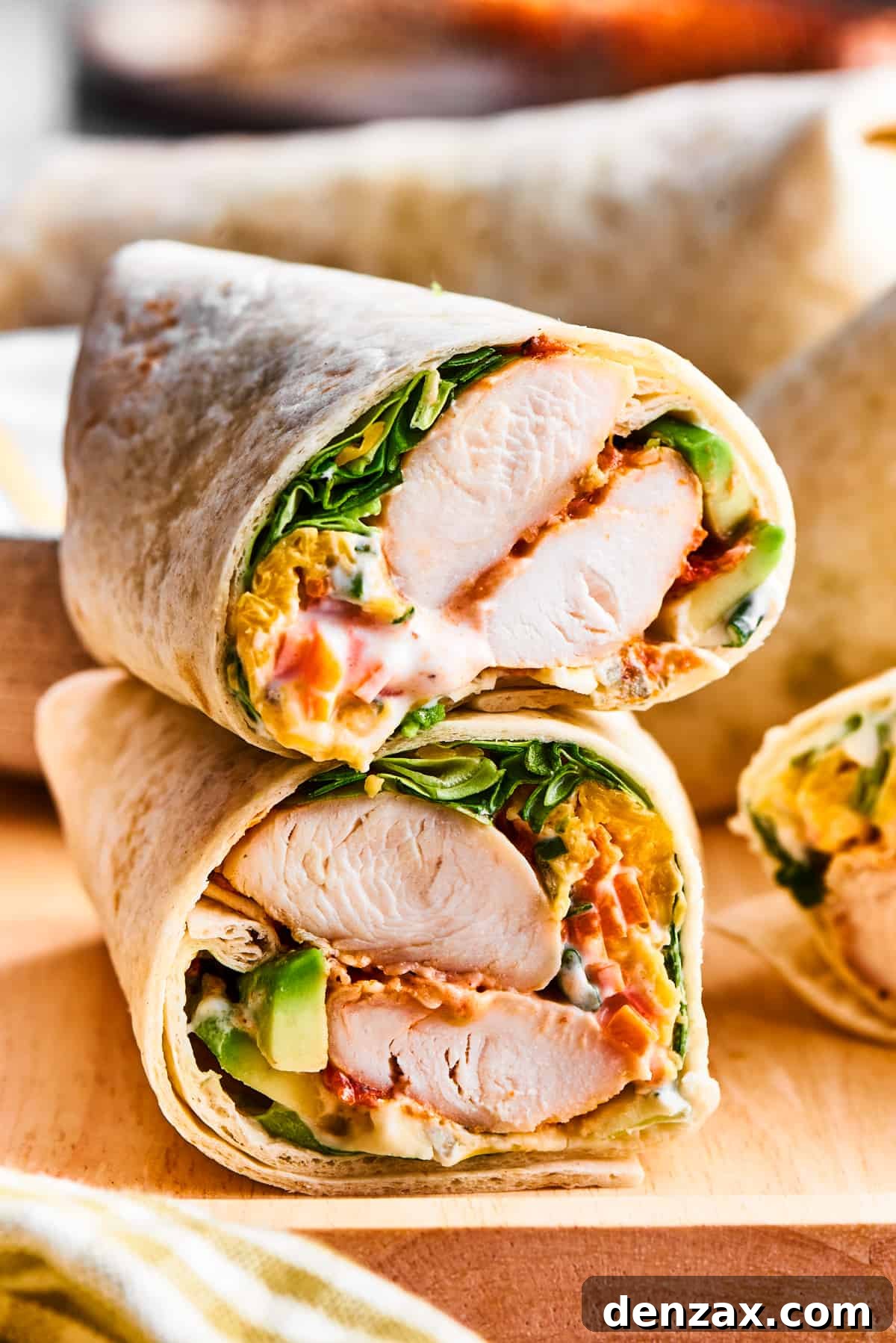 A perfectly cut Buffalo Chicken Wrap revealing layers of spicy chicken, fresh greens, cheese, and creamy dressing, ready to be enjoyed.