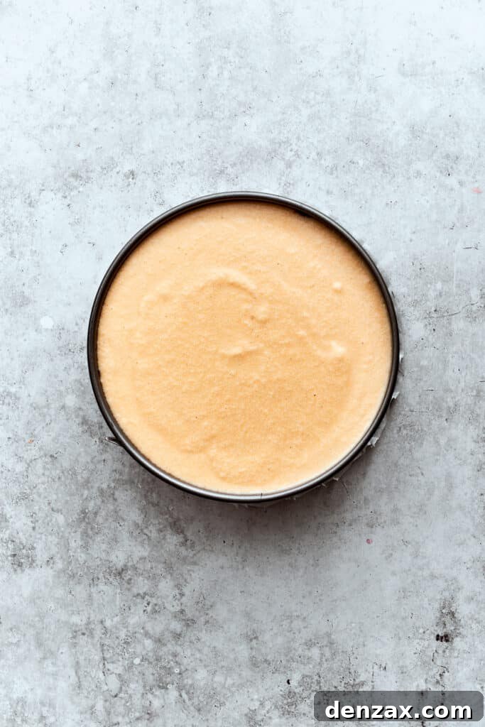 The turtle cheesecake is finished with a final, smooth layer of plain vanilla cheesecake batter before baking.