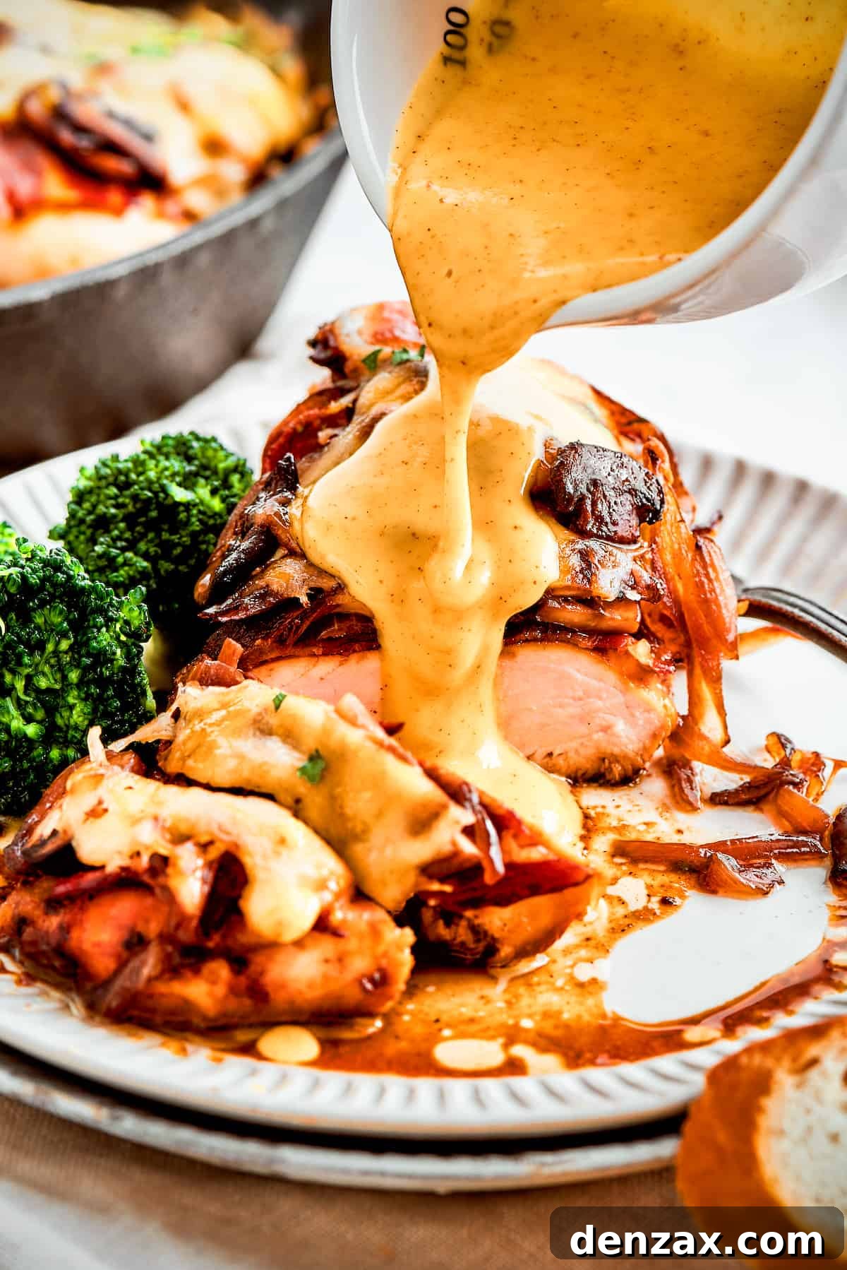A thick stream of vivid yellow honey mustard sauce is added to a plate of Alice Springs chicken, highlighting the vibrant colors and appealing texture of the dish.