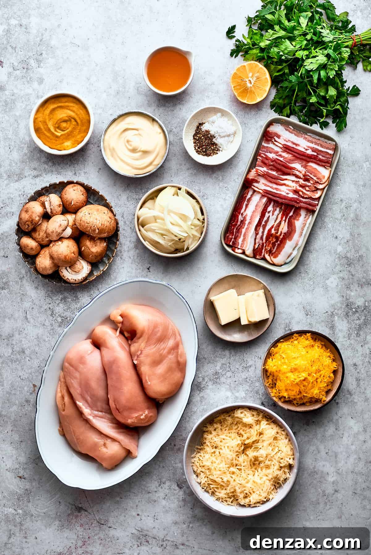 The ingredients to make Alice Springs chicken are shown portioned out: chicken, mushrooms, honey, mayo, mustard, garlic, onion, butter, bacon, salt and pepper, cheddar and Jack cheeses, ready for preparation.