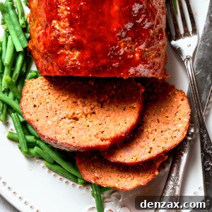 Overhead close-up photo of sliced brown sugar meatloaf served with green beans.