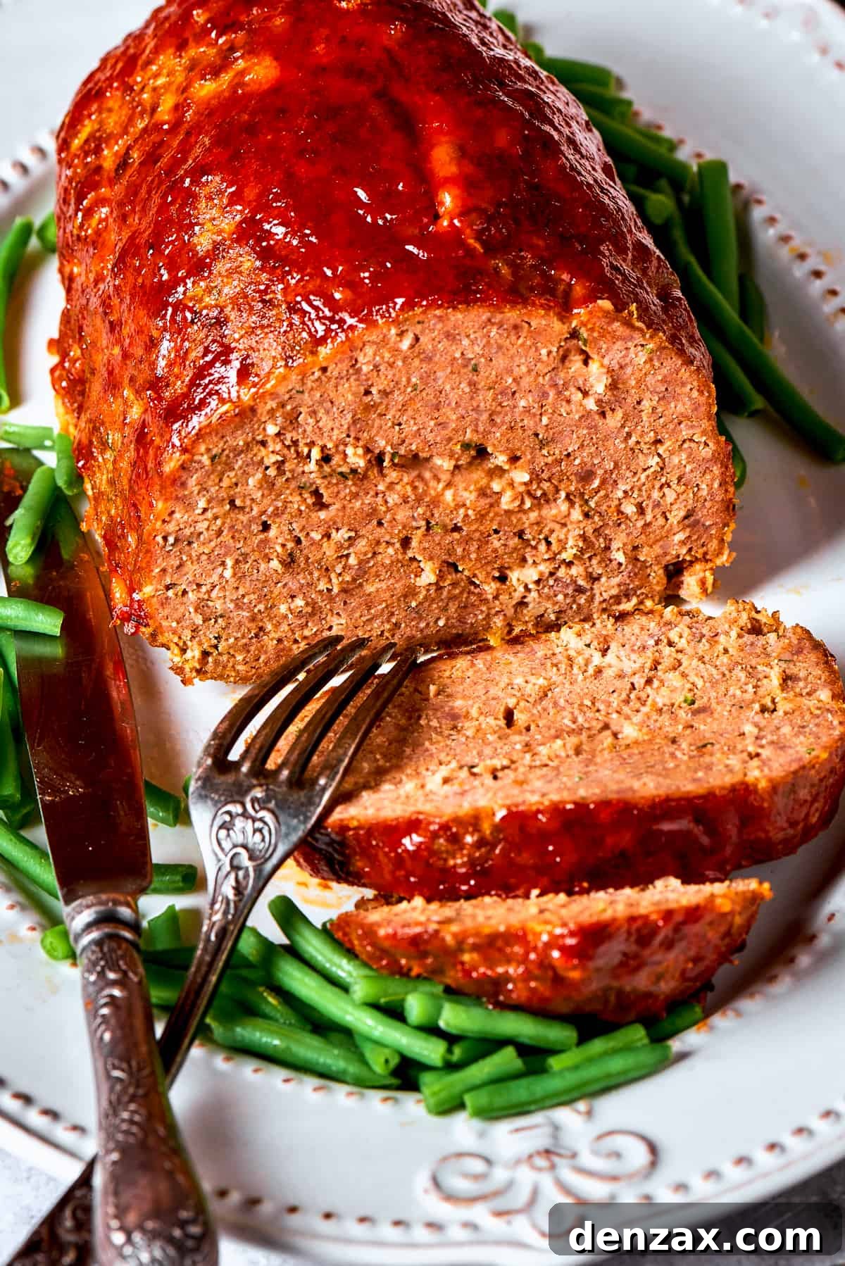 A side view of a sliced brown sugar meatloaf, exposing its texture.