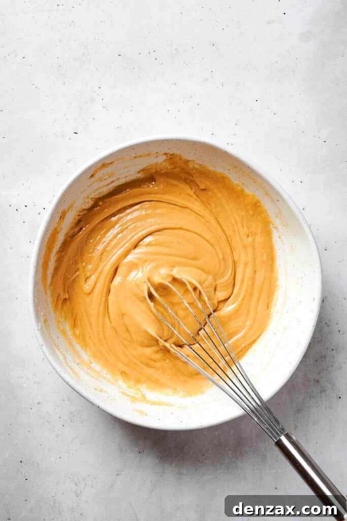 A whisk incorporates all of the ingredients into the batter to make blonde brownies.