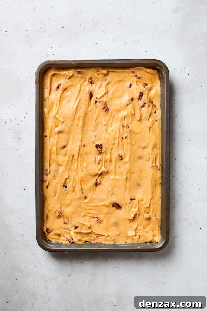 Blonde brownies batter is spread into a baking pan.