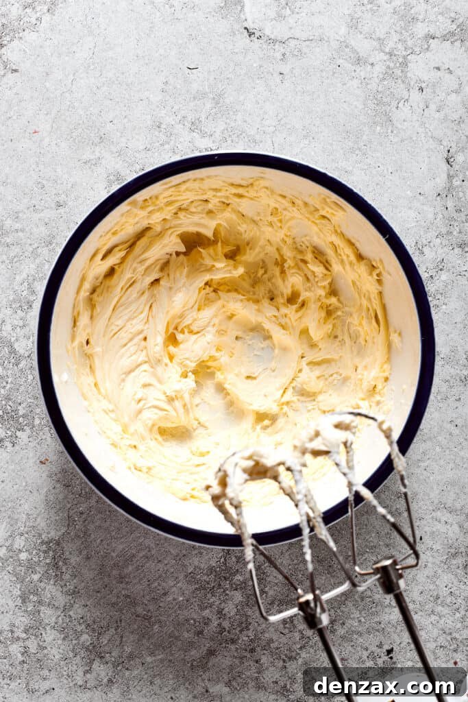 Softened butter is whipped into a light, fluffy consistency with a hand mixer, essential for the pie filling's texture.