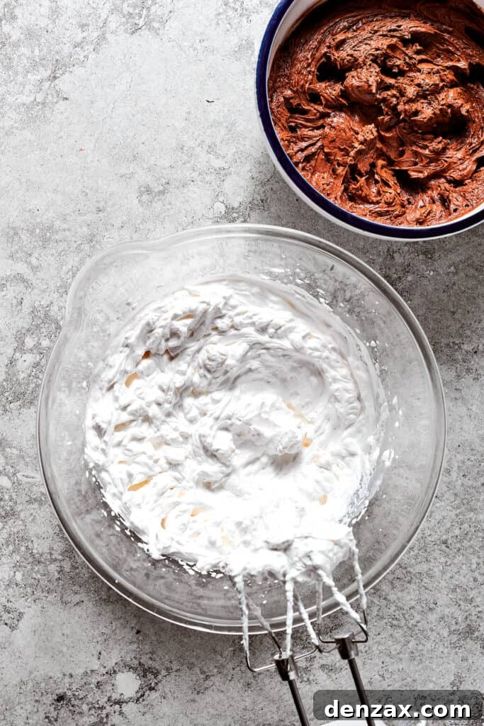 A bowl of light, fluffy whipped cream sits next to a bowl of rich chocolate filling, awaiting the final combination.