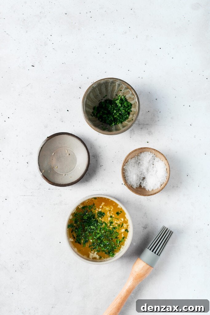 Bowls containing melted butter, minced garlic, chopped parsley, and a pinch of salt, ingredients for the garlic butter glaze.