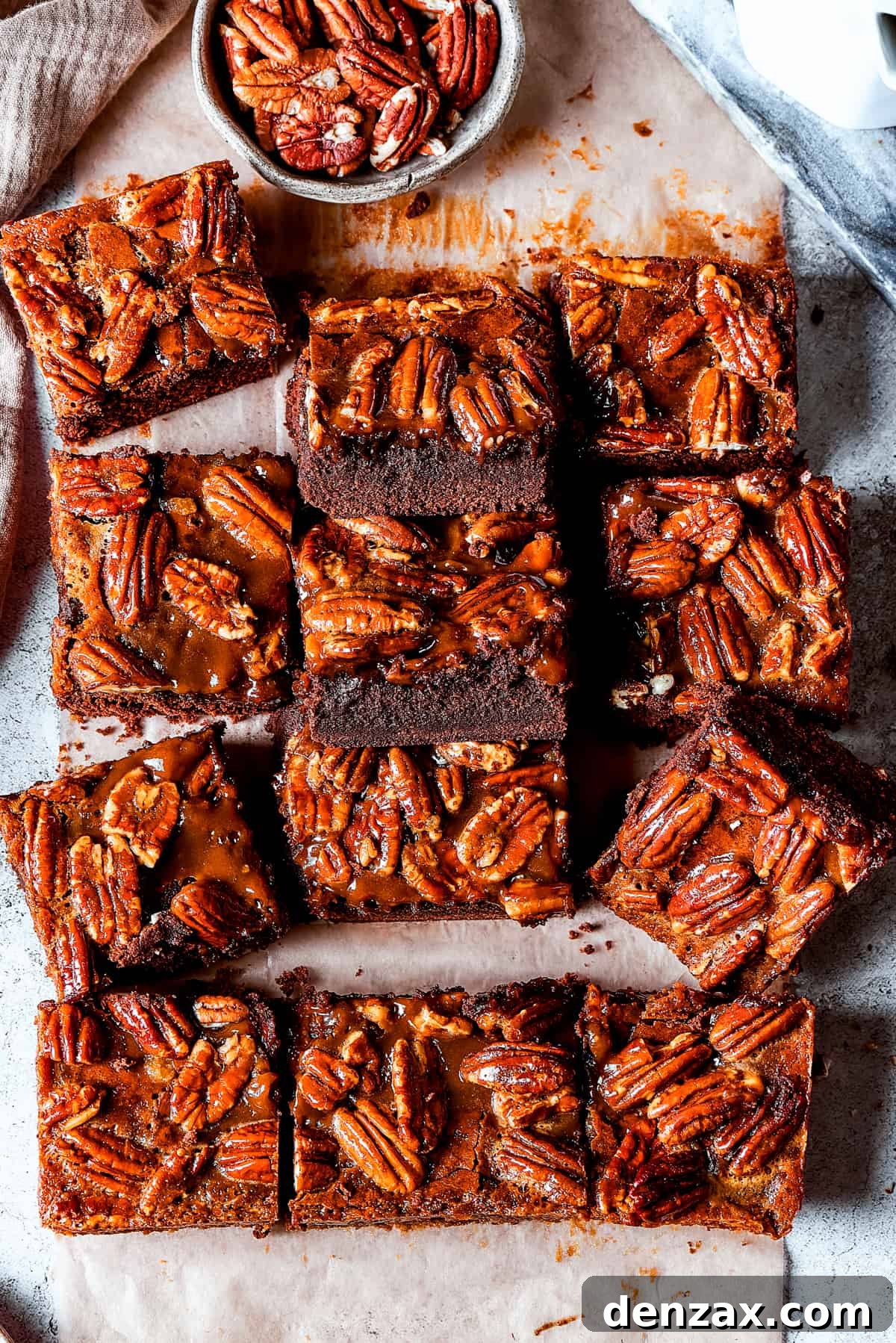 Artfully arranged pecan brownie squares on a bright, minimalist surface, ready to be enjoyed.