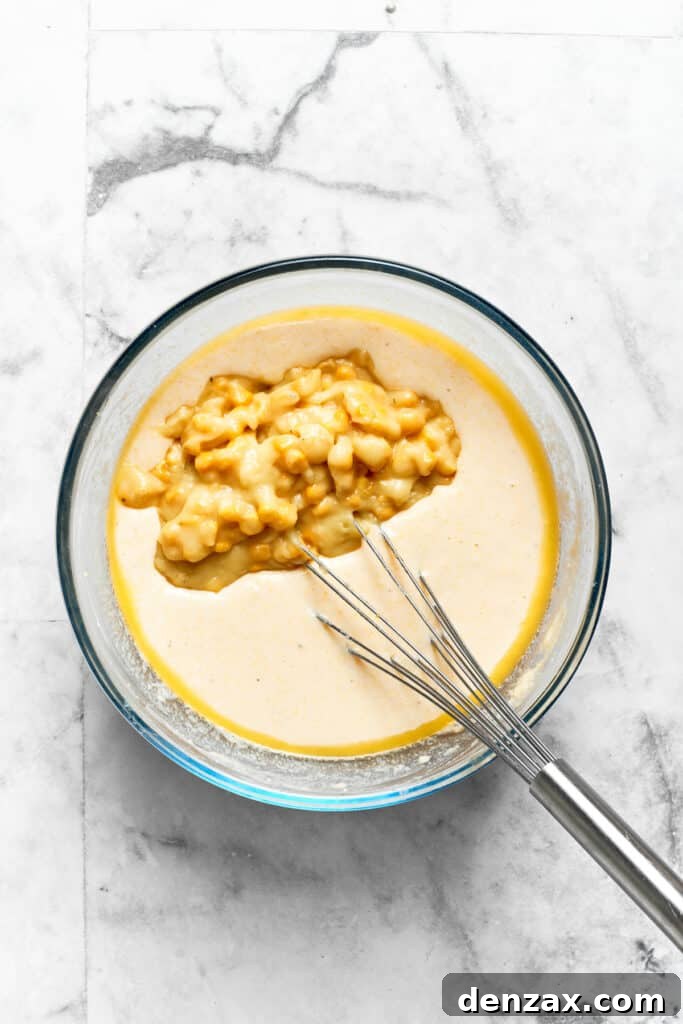 Creamed corn is gently stirred into the Spoon Bread batter, ensuring even distribution for flavor and texture.