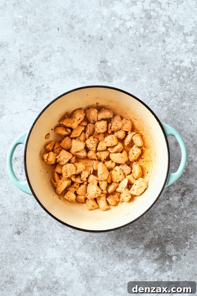 Chicken pieces cook in a pot.