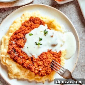 Chicken-fried steak served over mashed potatoes, drenched in creamy gravy.