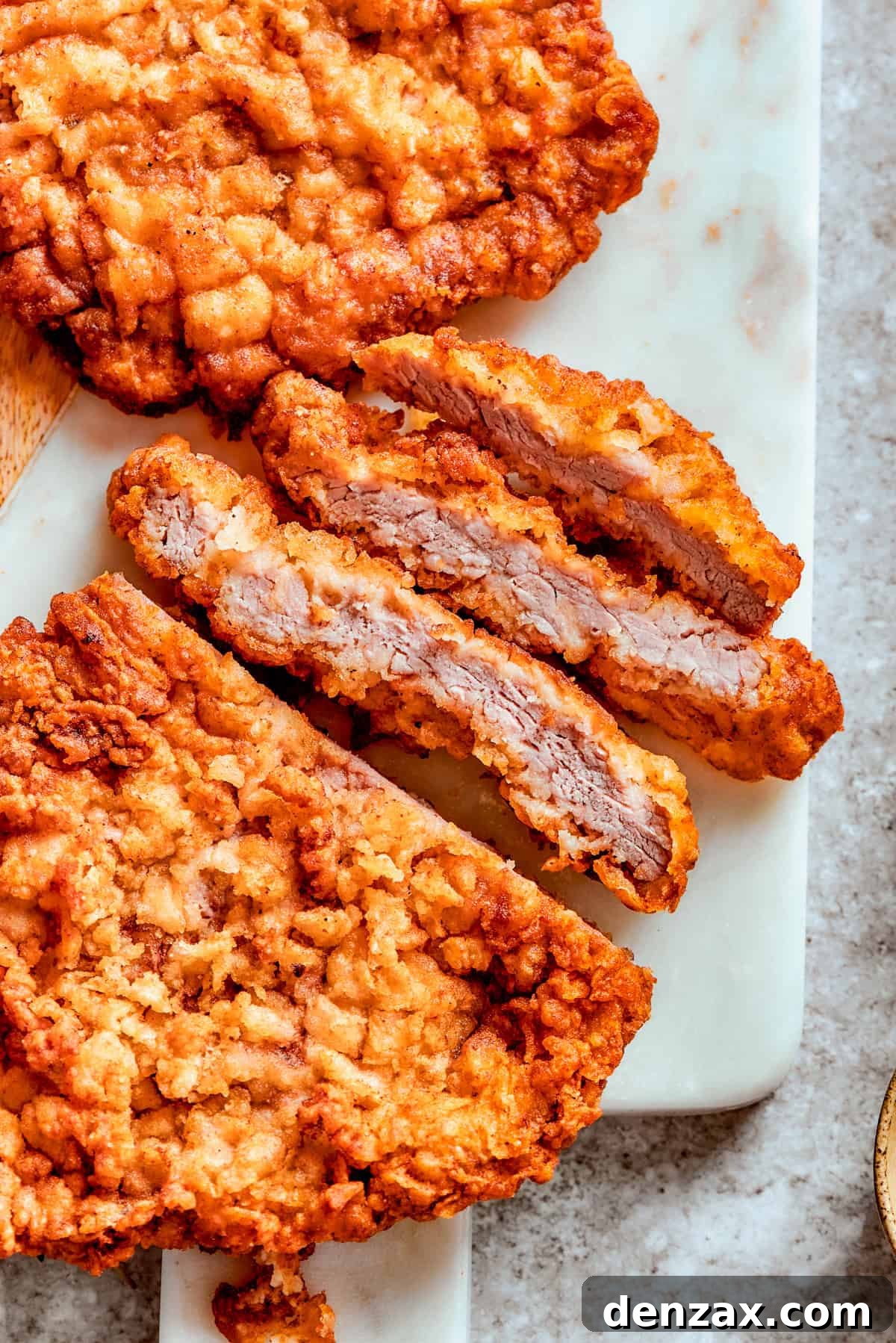 A perfectly fried cube steak, sliced to reveal its tender interior and crispy crust.