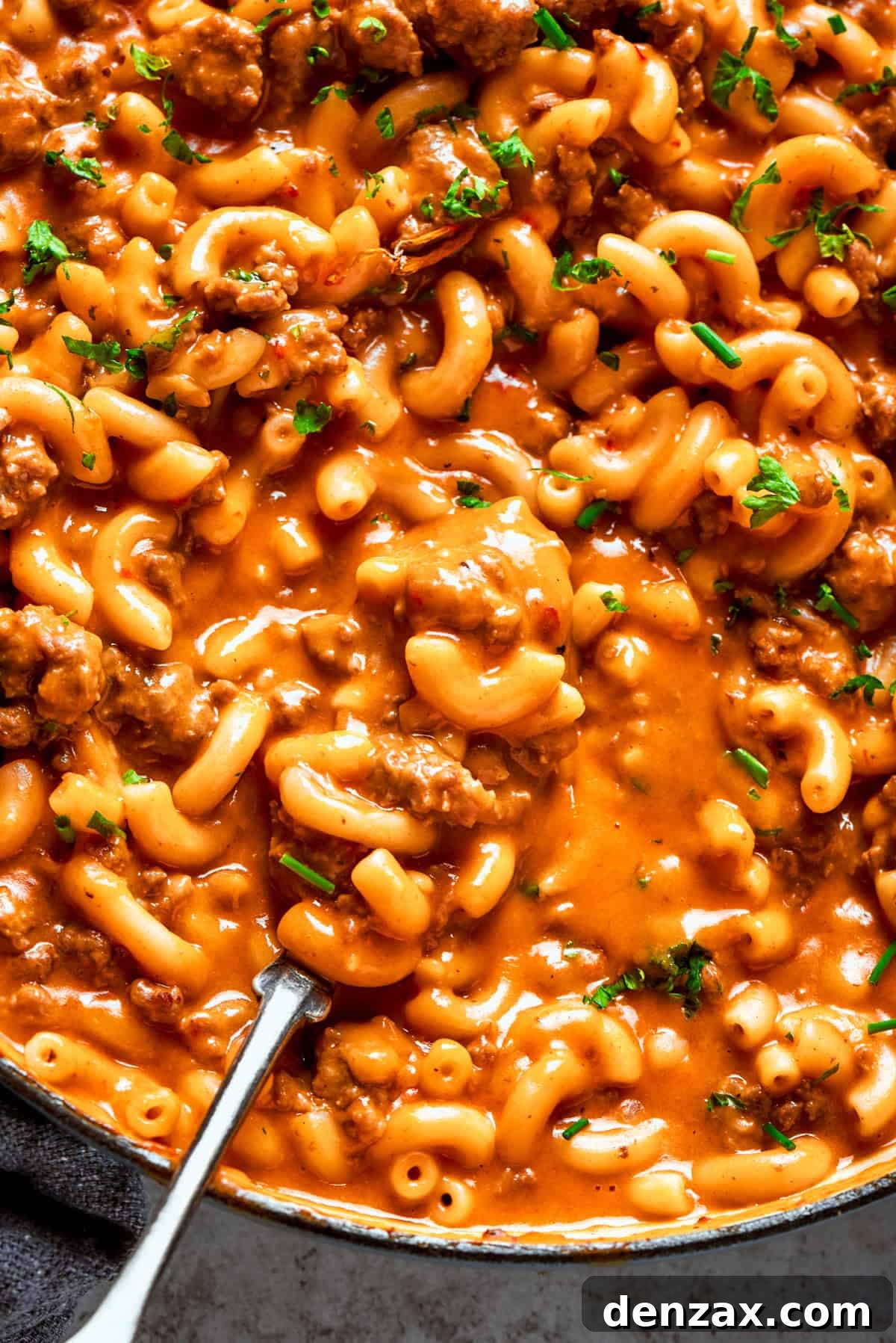 Close-up photo of a generous serving of homemade hamburger helper, featuring elbow macaroni coated in a rich, cheesy ground beef sauce.