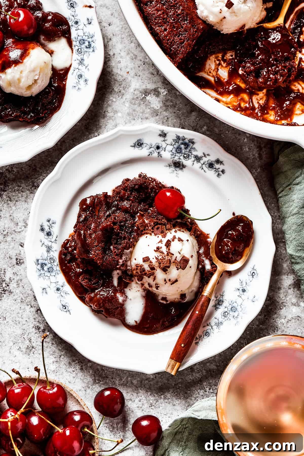 A slice of chocolate pudding cake presented on a white dessert plate, adorned with a scoop of perfectly melting vanilla ice cream.