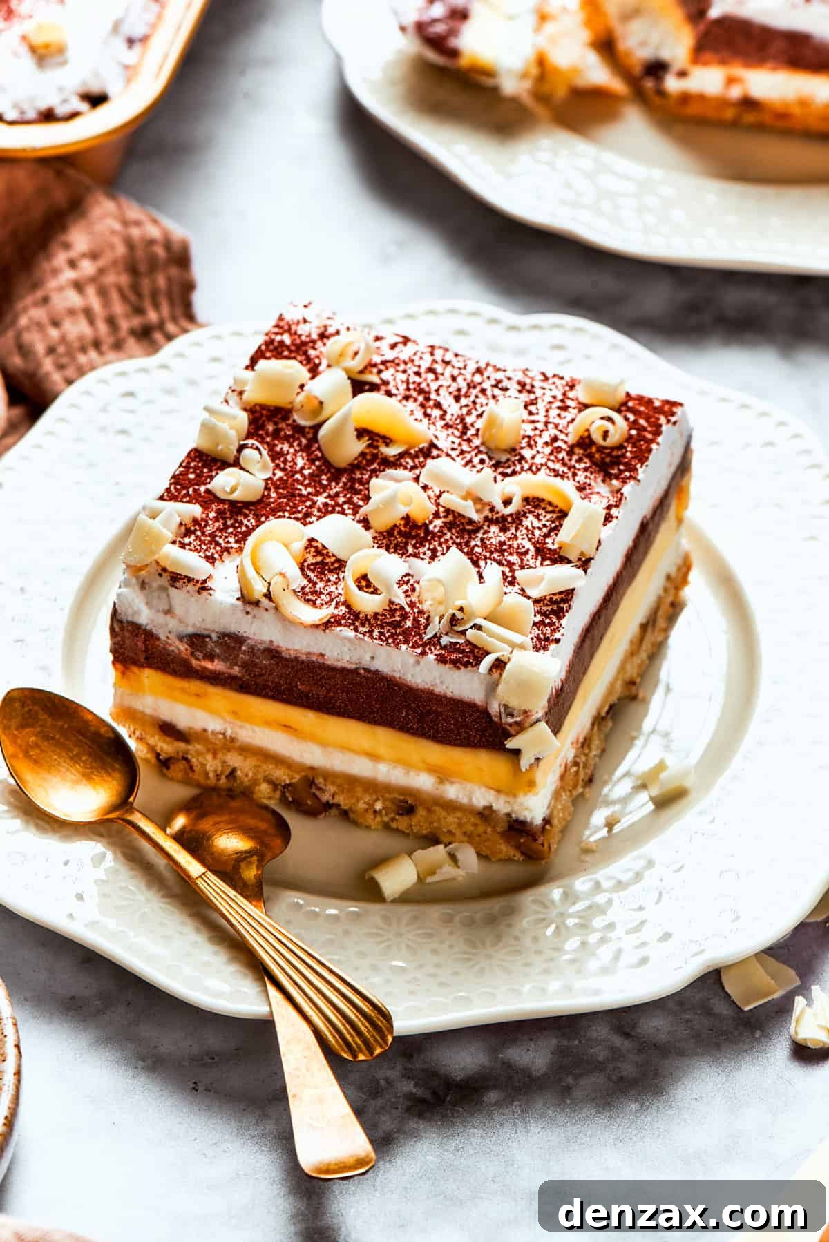 A delectable slice of Sex in a Pan dessert showing its layers, topped with pecans and white chocolate shavings.