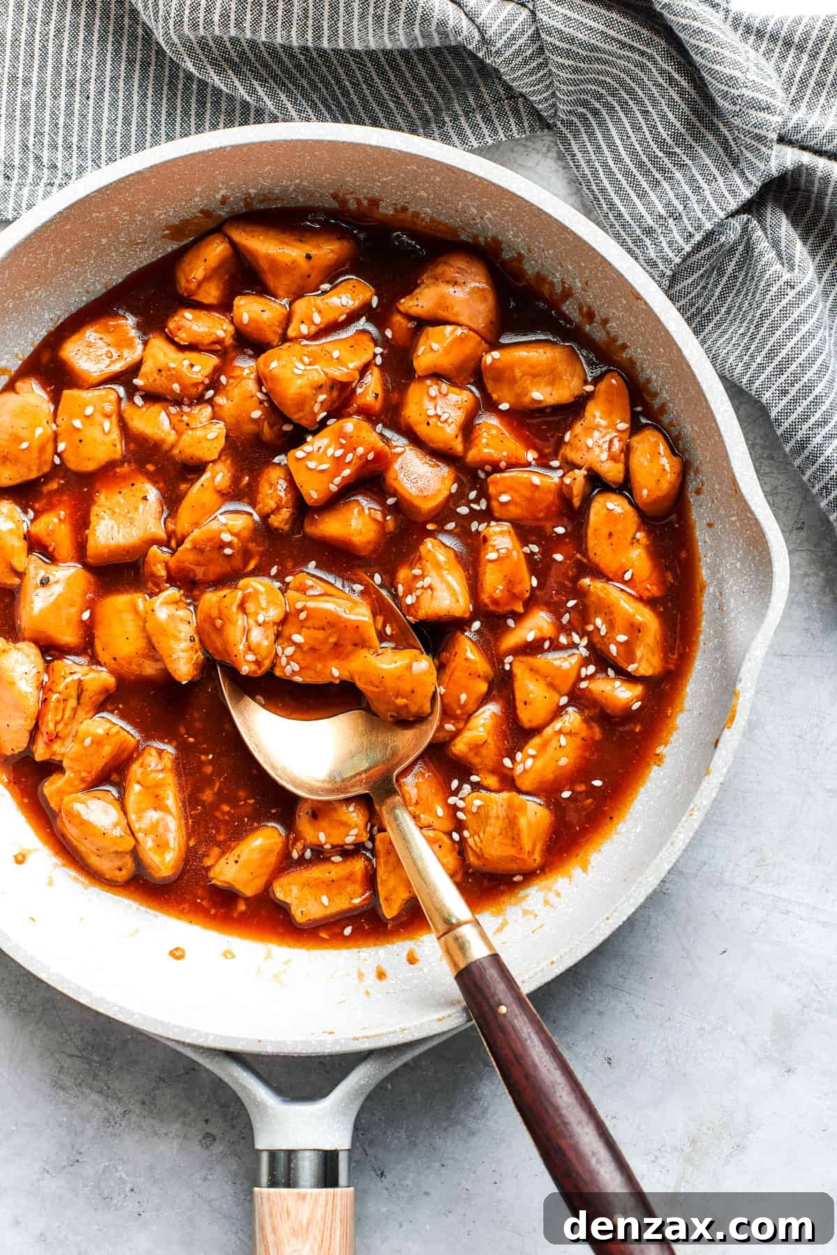 This Teriyaki Chicken Recipe folds tender bites of chicken into a thick, homemade teriyaki sauce for a savory and flavorful dish. Cubes of chicken cooking in a sauce.