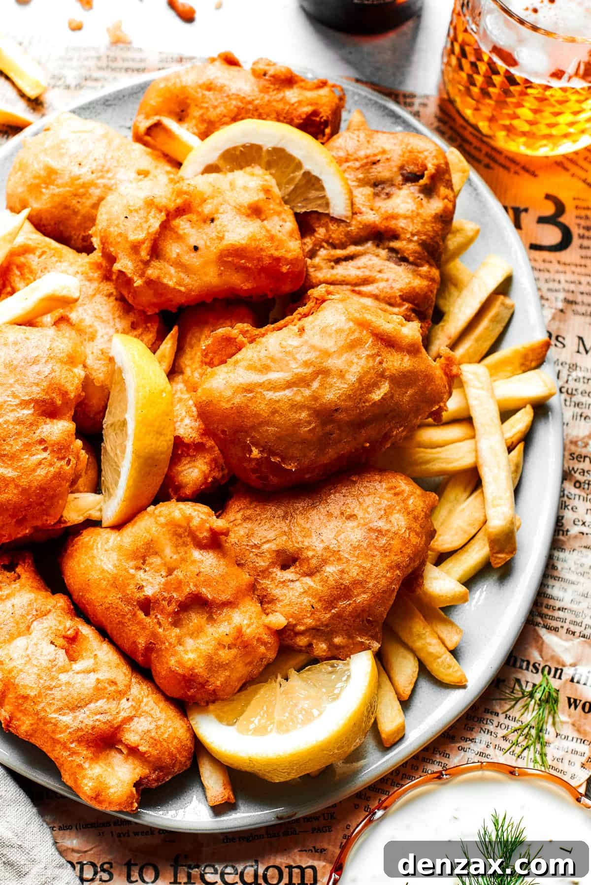 A beautifully arranged platter showcasing beer-battered fish fillets alongside a generous serving of crispy chips.
