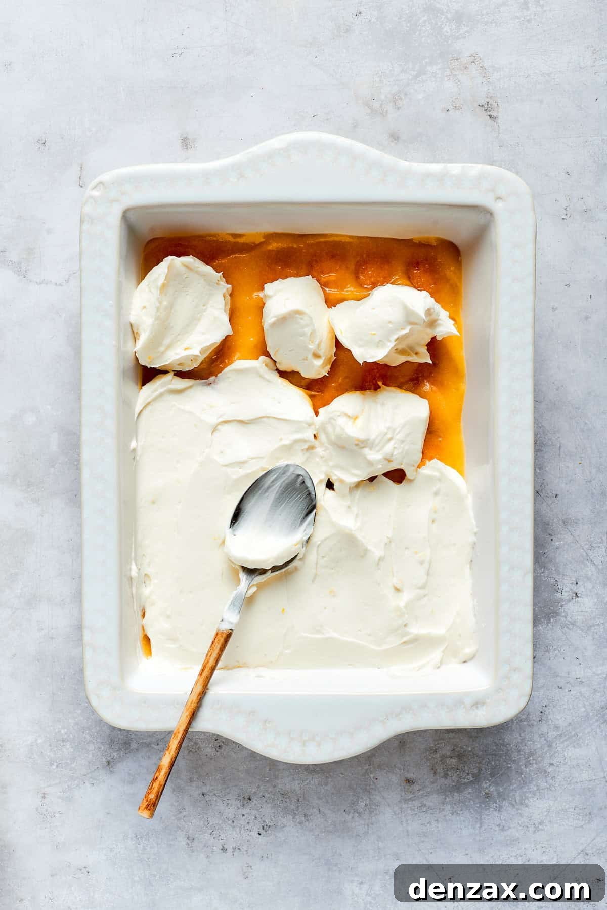 A thick, creamy layer of mascarpone filling is spread over the lemon curd, creating a luscious middle layer.