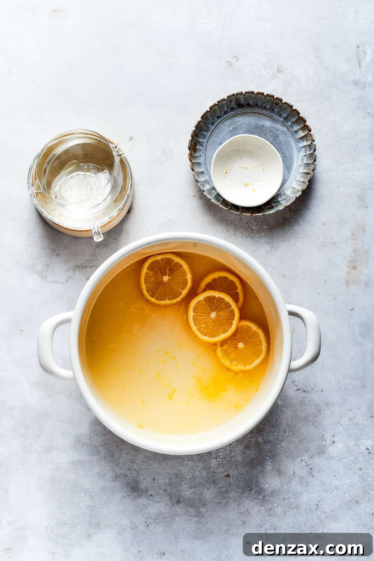 Lemon juice, water, sugar, and lemon zest are combined in a saucepan to create the lemon syrup.