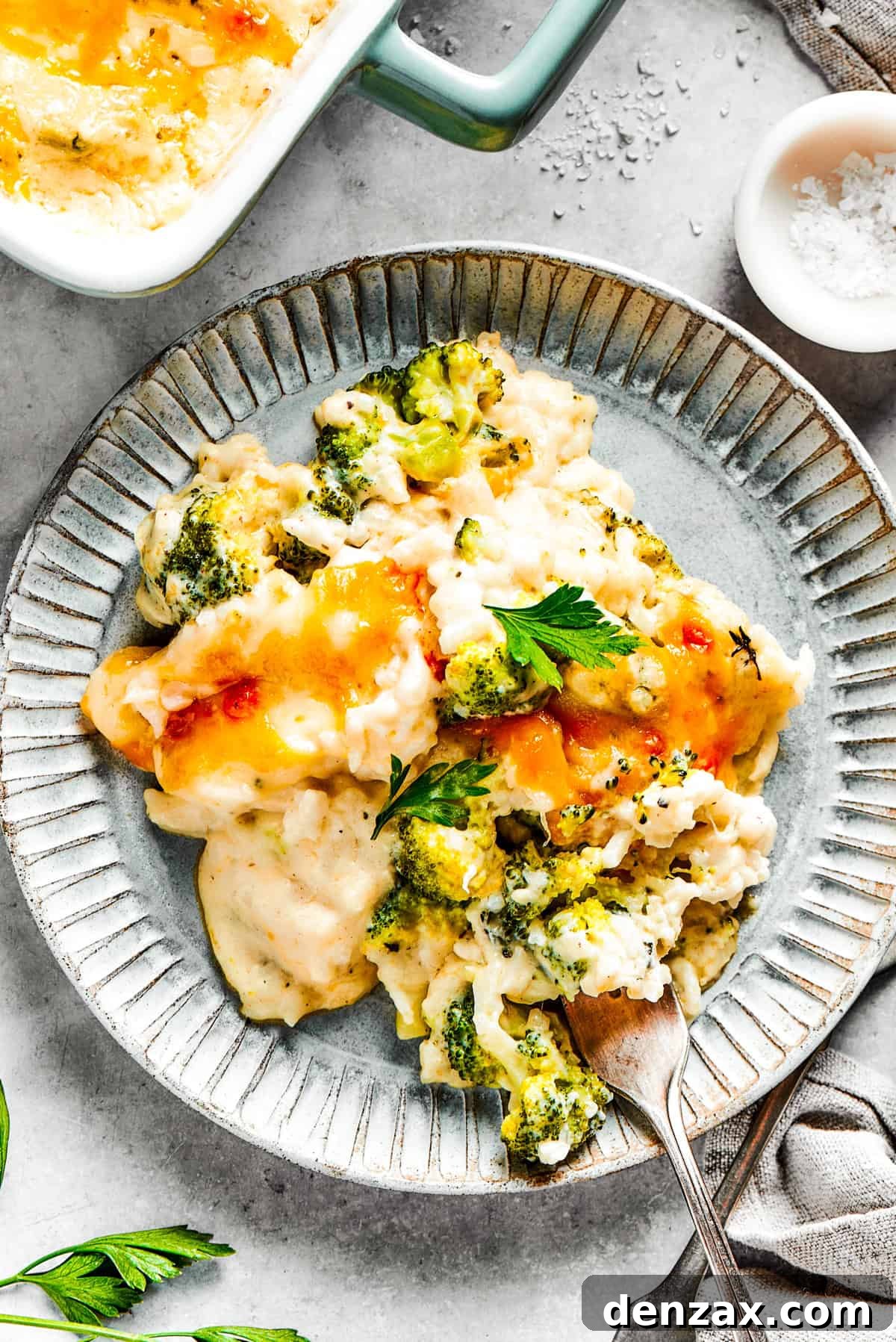 A serving of broccoli & rice casserole on a blue plate with a fork.