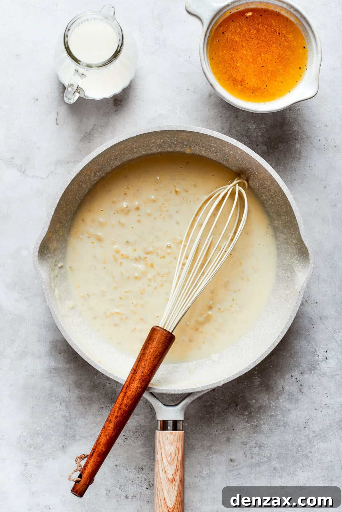 Cheese sauce is whisked in a pot.