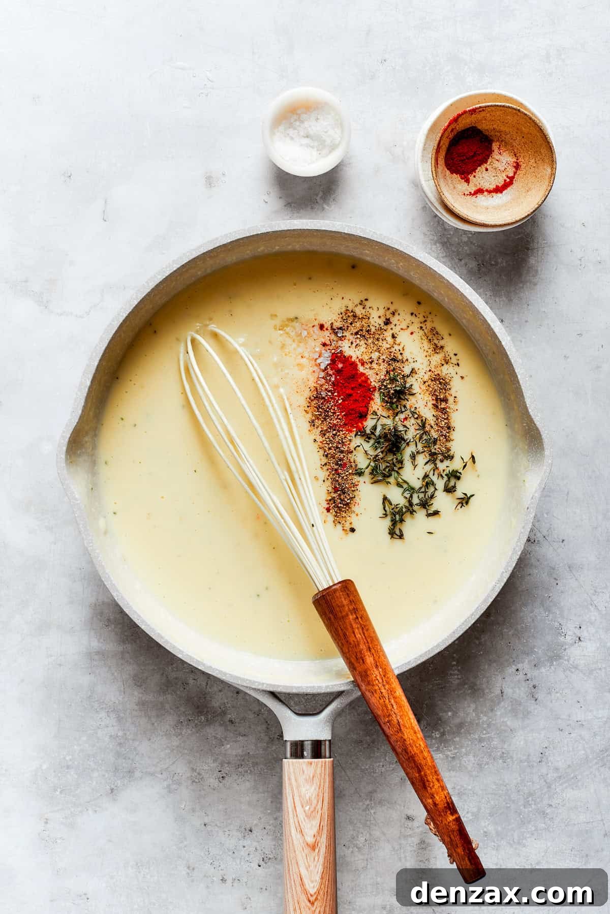 Seasonings are added to roux in a pot.