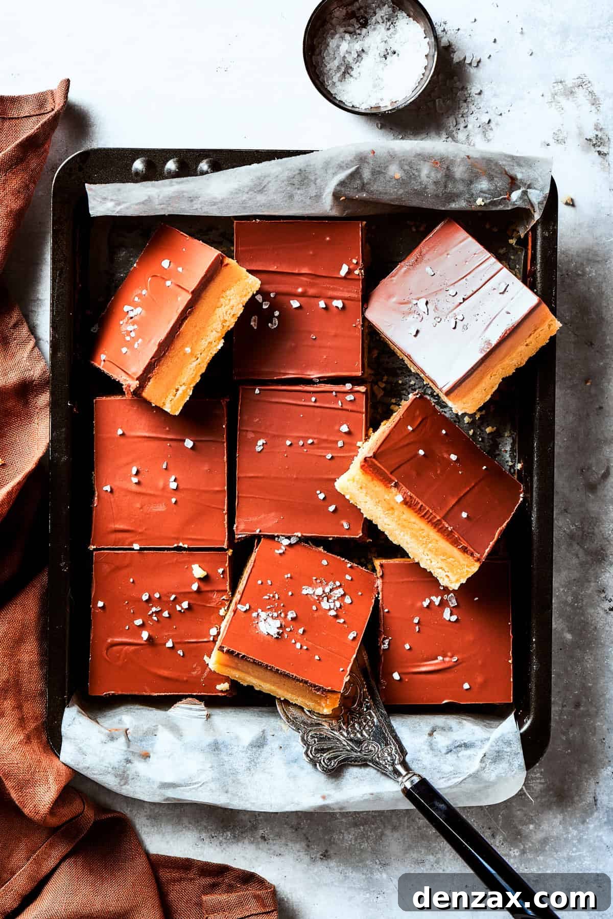 A square pan of freshly made Millionaire bars, perfectly set and ready to be cut and enjoyed.