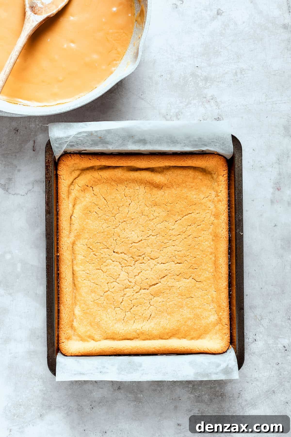 Baked shortbread crust cools in a pan, golden brown and perfectly set.