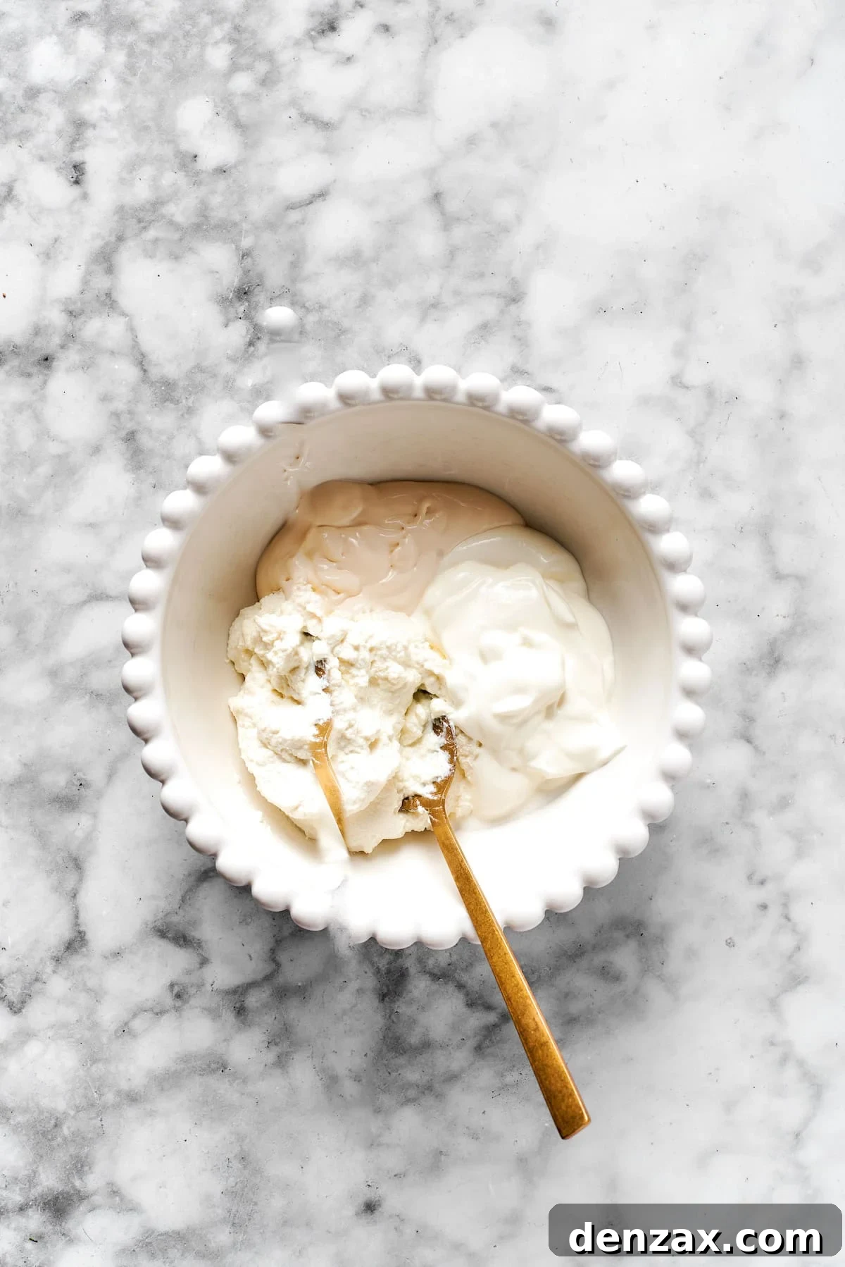 Ingredients for the cheese mixture (ricotta, cream cheese, sour cream) in a white bowl, ready to be combined.