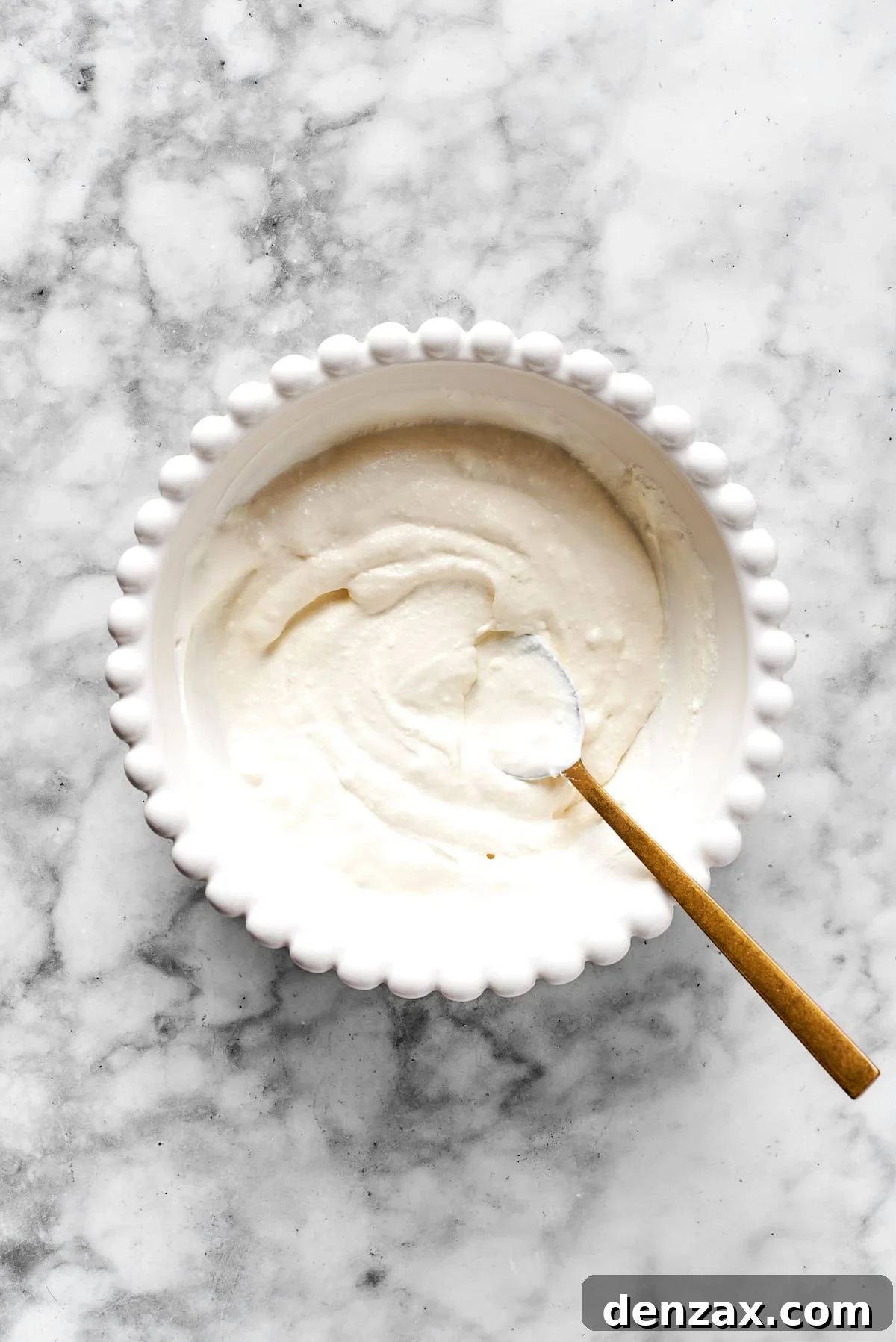Finished, smooth cheese mixture in a white bowl, showing the desired creamy texture.