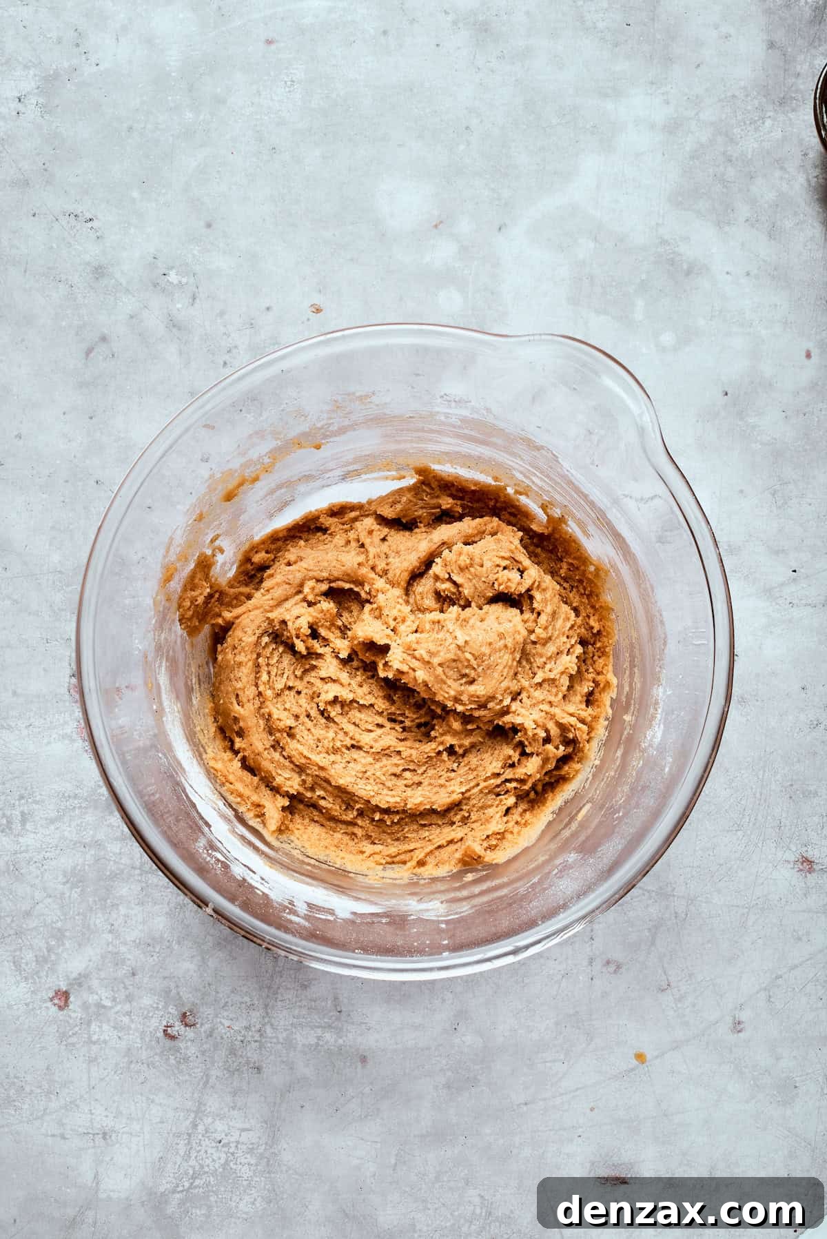 A bowl of rich, thick cookie dough, perfectly mixed and ready for chocolate chips.