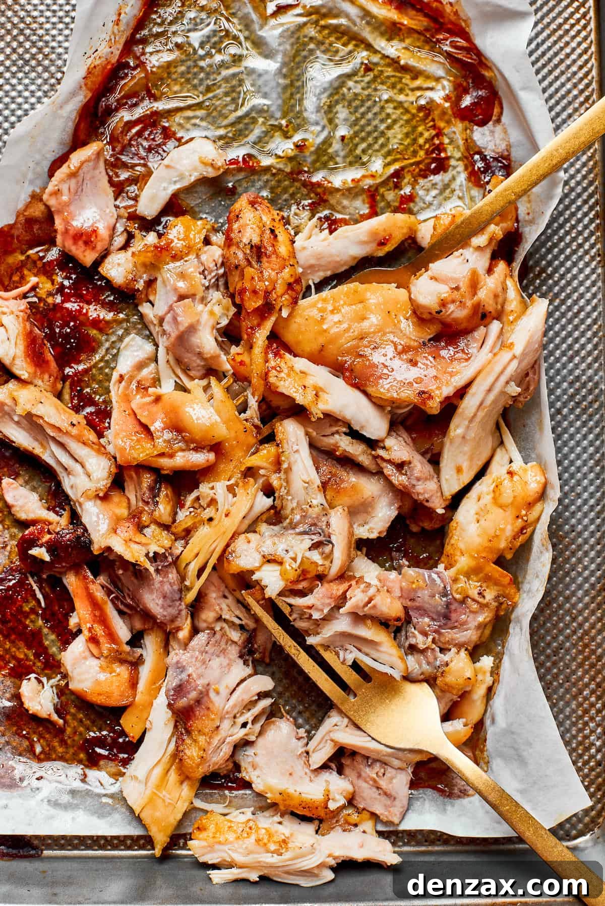 Perfectly roasted and shredded chicken on a baking sheet, ready to be added to the pasta.