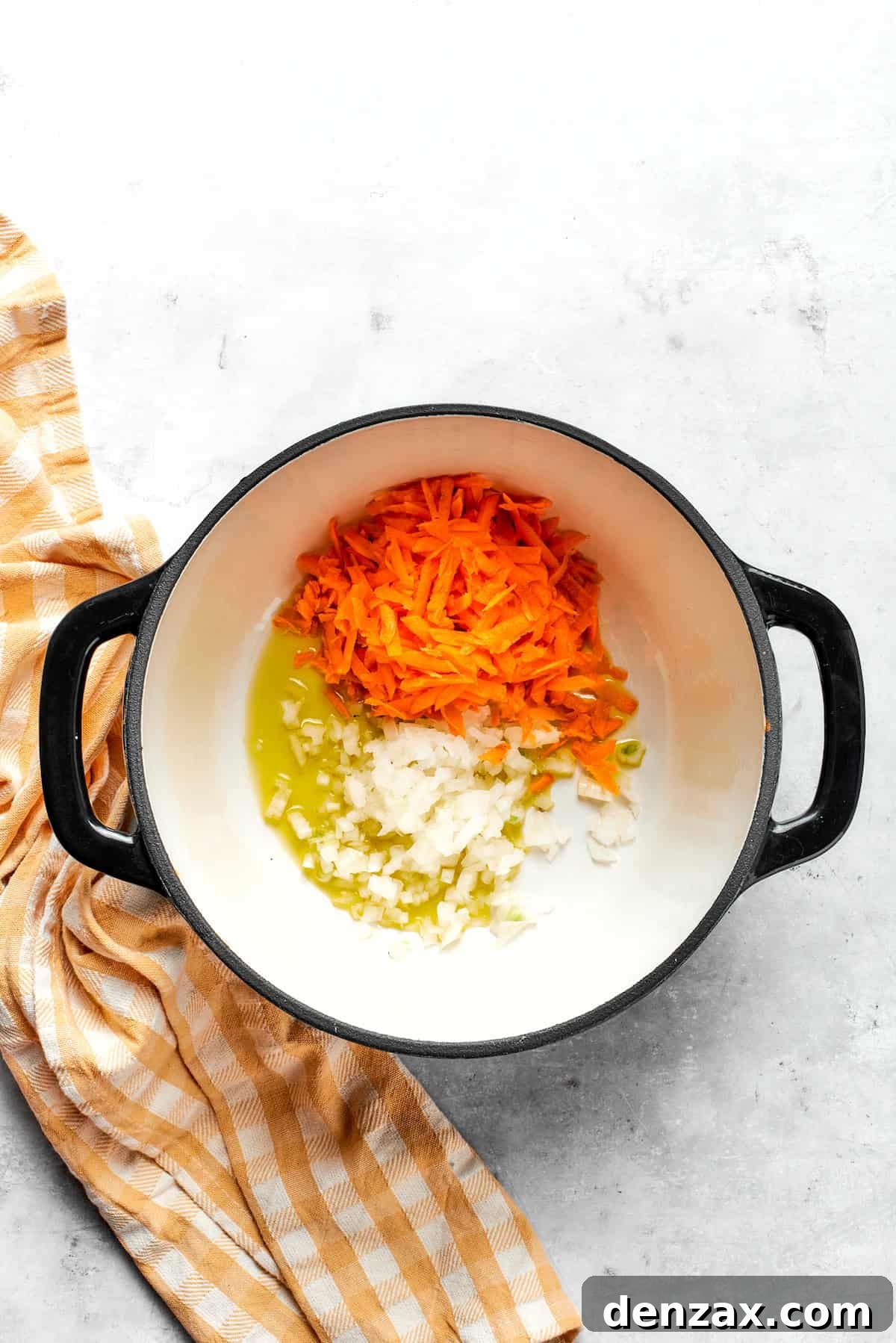 Sautéing diced carrots, onion, and minced garlic in olive oil in a large soup pot until softened and fragrant.