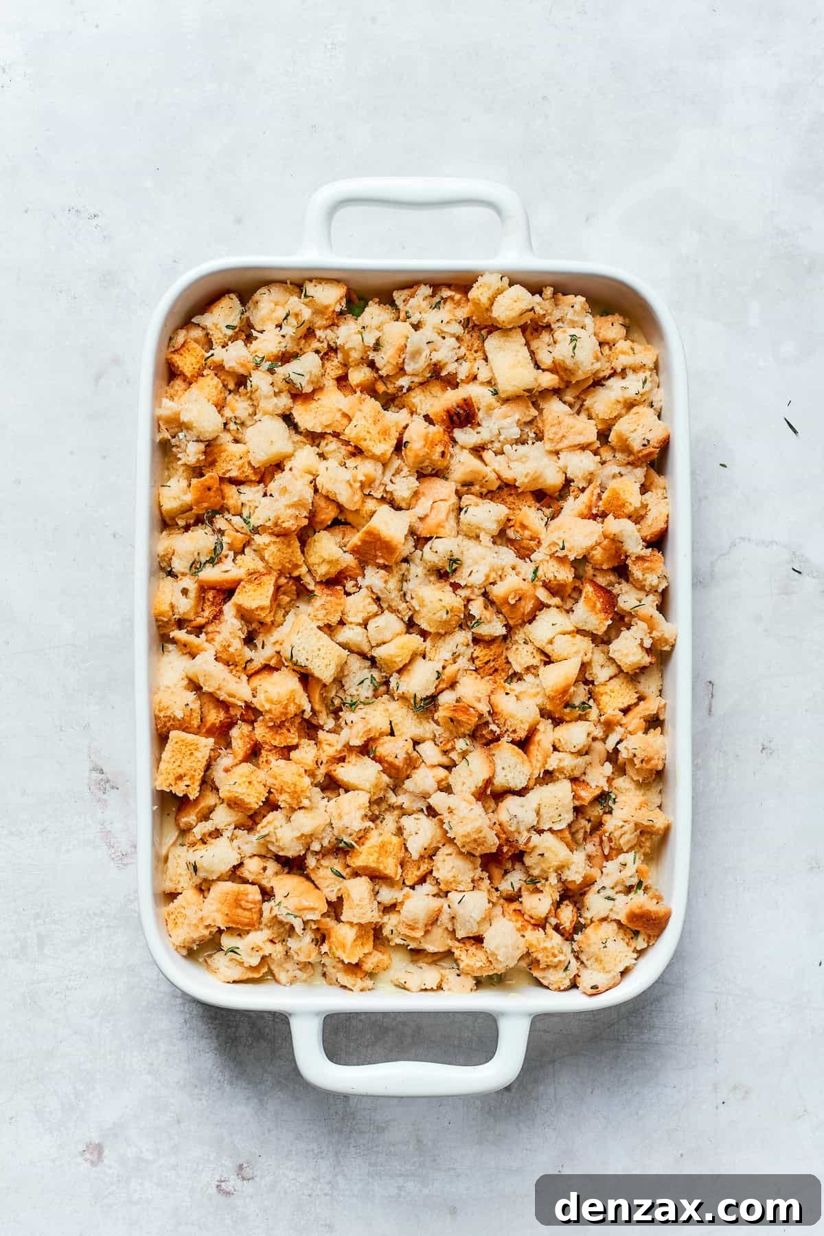 Adding an even layer of stuffing on top of the chicken filling.