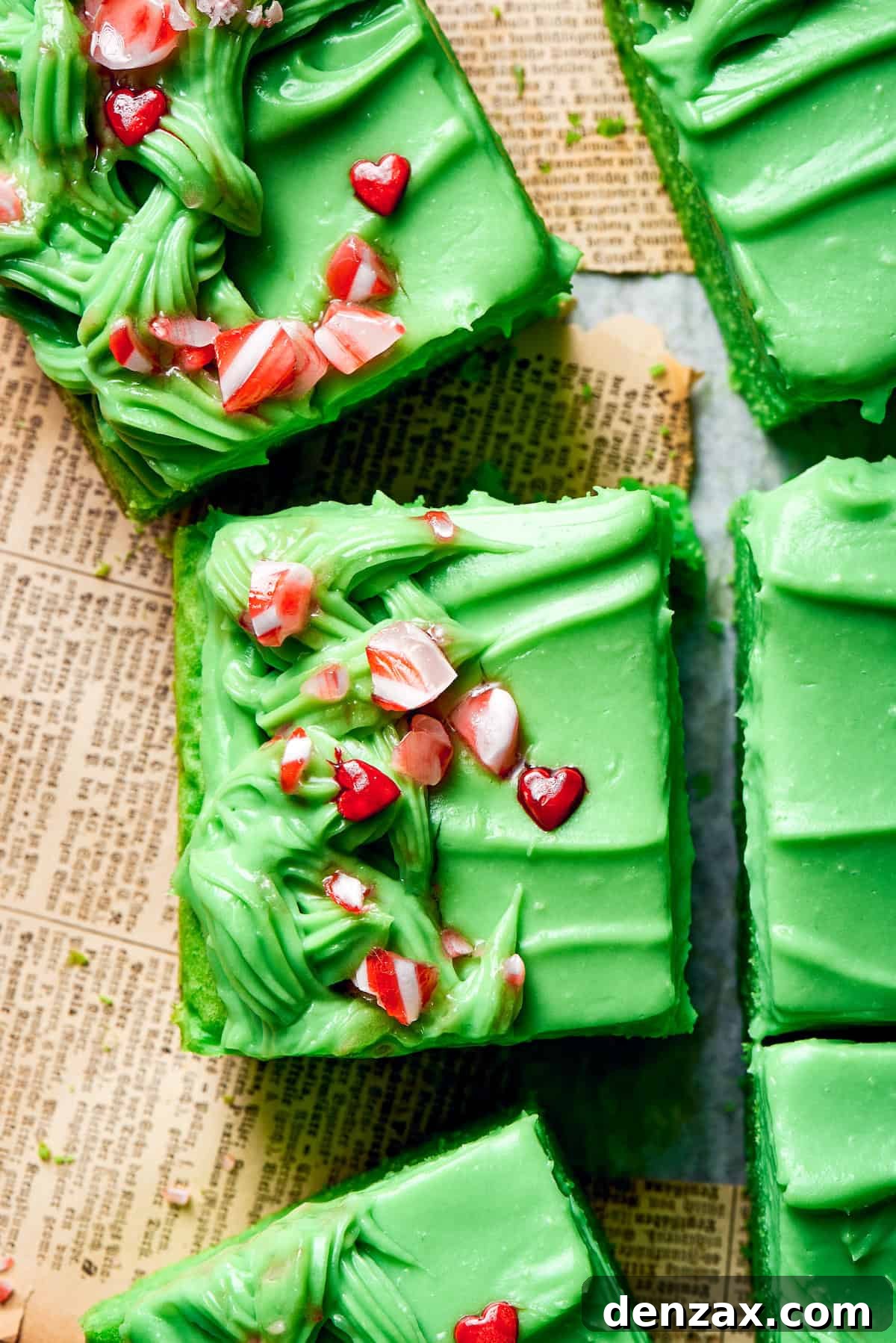 Festive Grinch Cake: Topped with Crushed Candies and Heart Sprinkles Crushed candy and red heart sprinkles generously top individual slices of grinch cake, highlighting the festive decor.